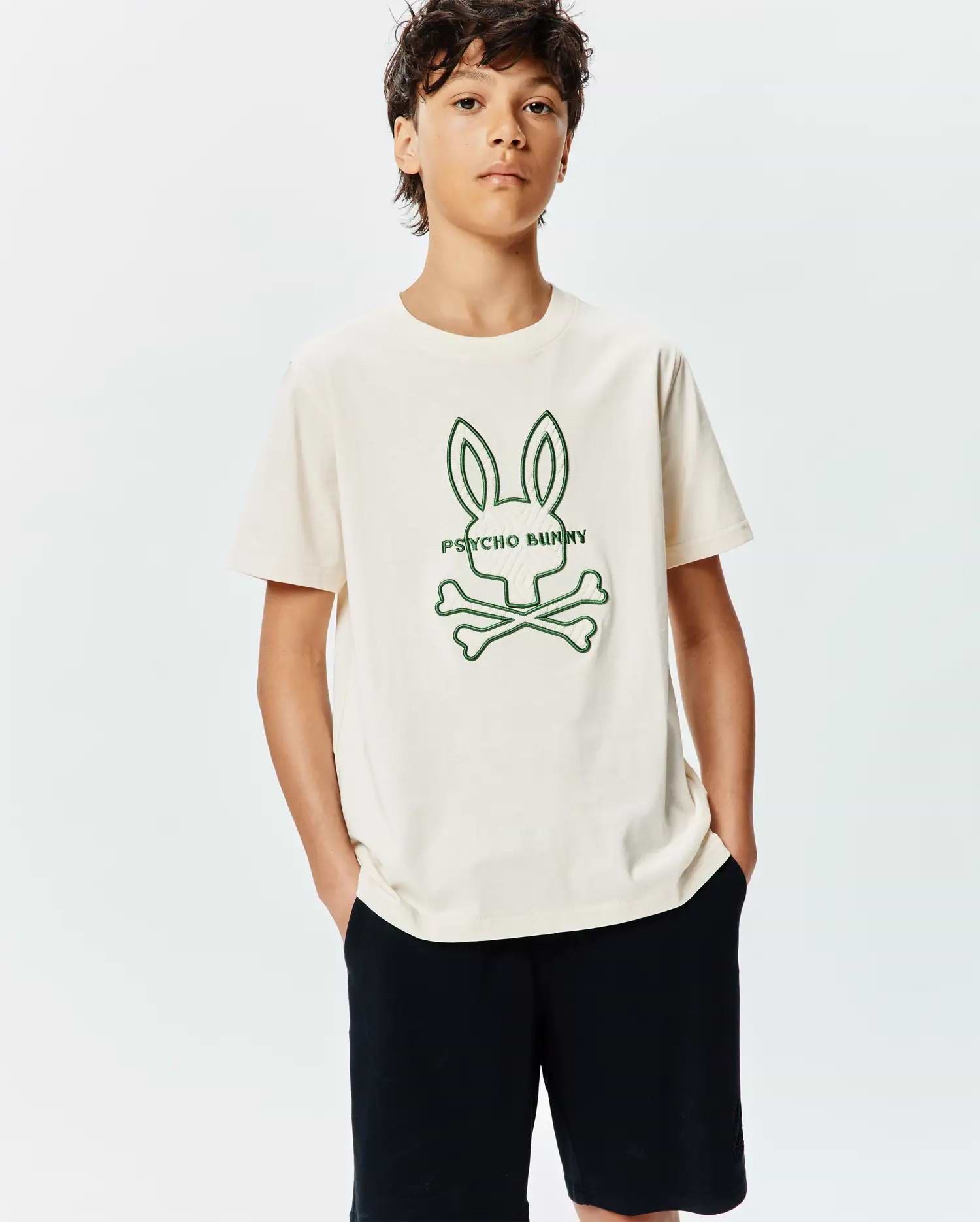 Kids Craig Graphic Tee in cream jersey, featuring a relaxed fit with a prominent green embroidered Psycho Bunny skull and crossbones logo on the center chest. (2)