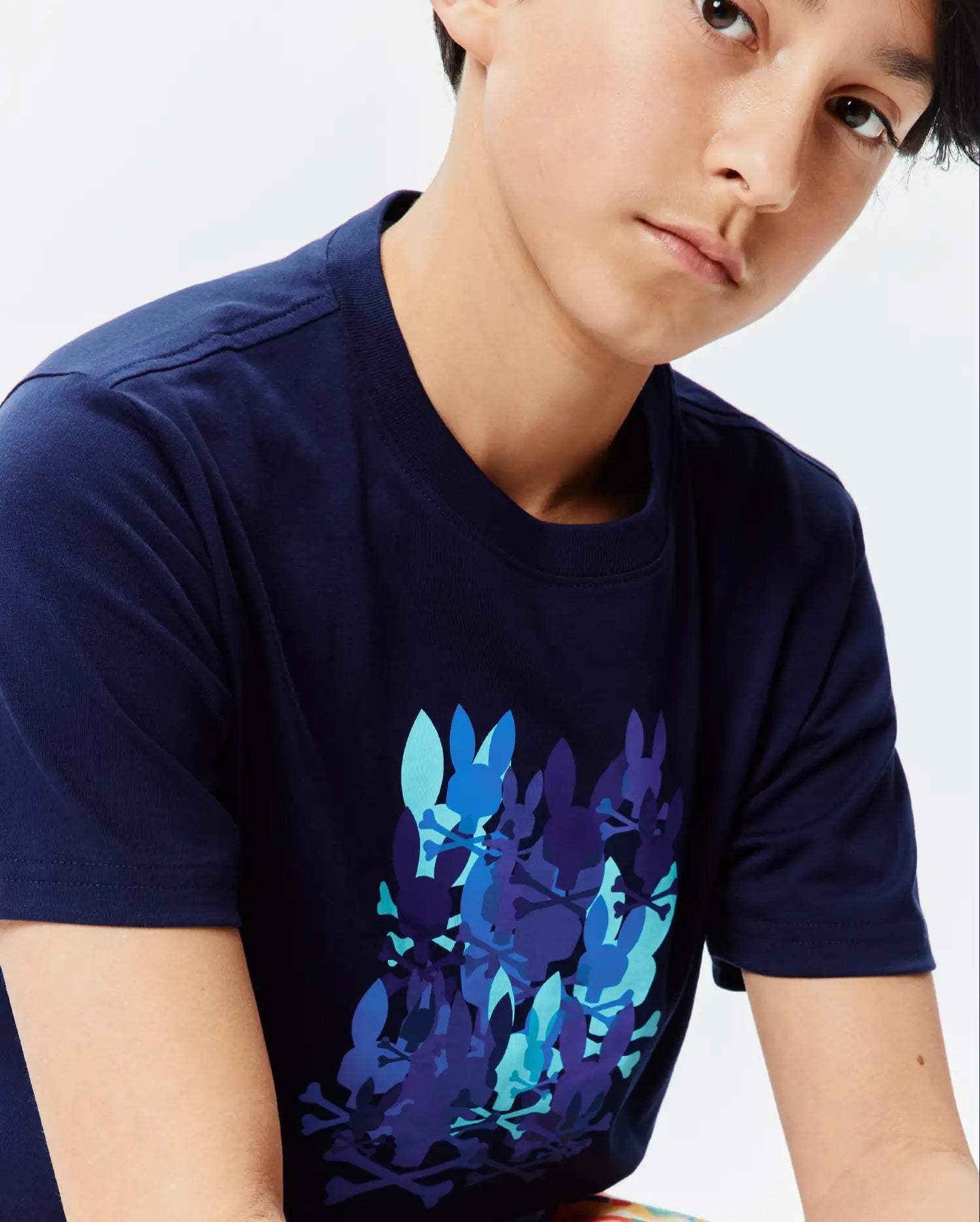 Kids Tanner Graphic Tee in navy, featuring a large chest graphic of overlapping Psycho Bunny skull logos in shades of blue, from light aqua to deep indigo, on a classic fit jersey knit.
