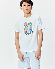 Kids Tanner Graphic Tee, a classic fit white jersey t-shirt featuring a large, vibrant central graphic of stacked, multicolored Psycho Bunny skull and crossbones logos in blue, green, yellow, pink, and orange.