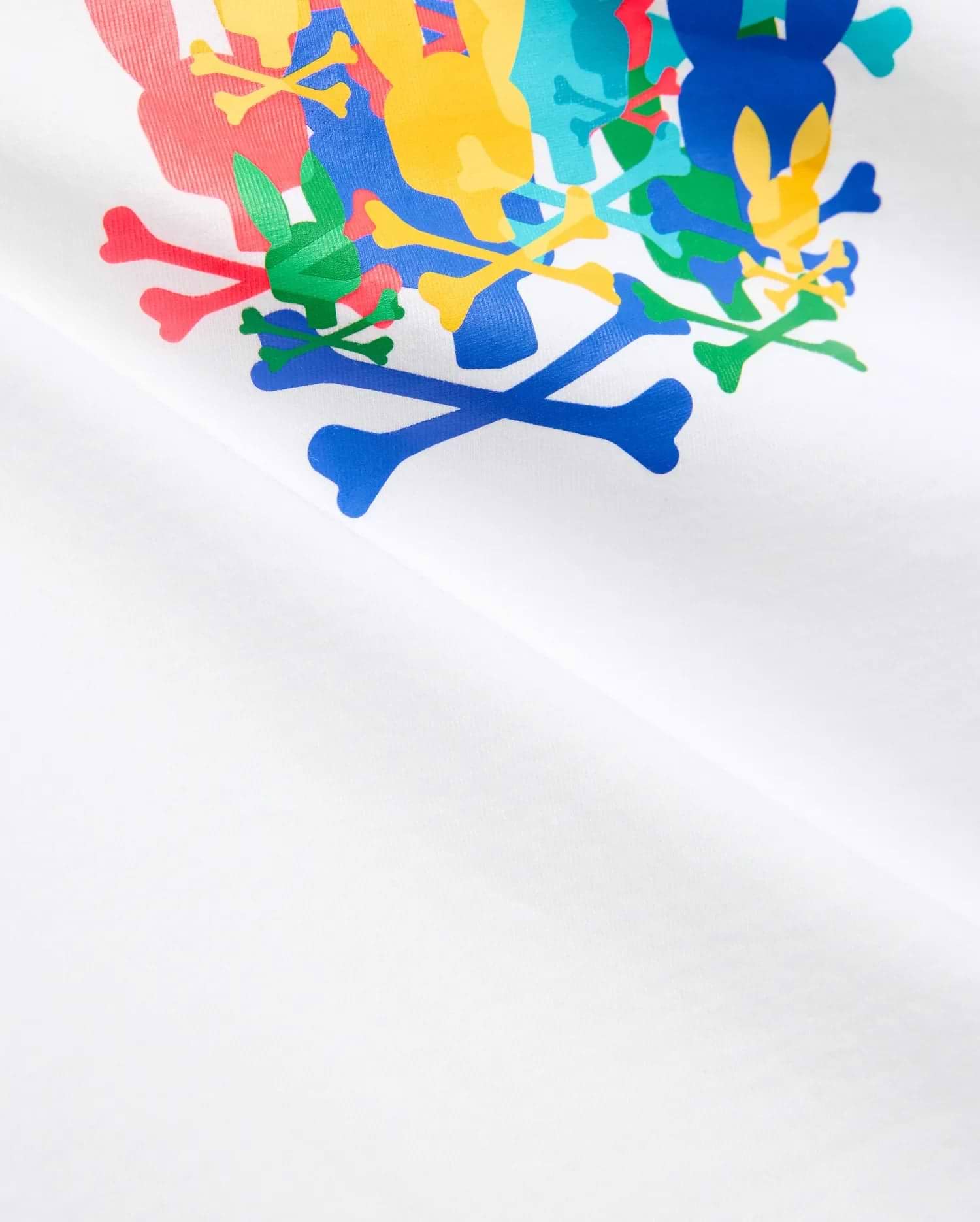 Kids Tanner Graphic Tee, white jersey t-shirt featuring a large, vibrant, overlapping Psycho Bunny skull and crossbones graphic print on the chest in red, green, blue, yellow, and light blue.