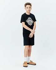 Kids Tobias Graphic Tee, black jersey knit, classic fit, featuring a large central white and grey Psycho Bunny skull and crossbones diamond graphic with vertical brand name.