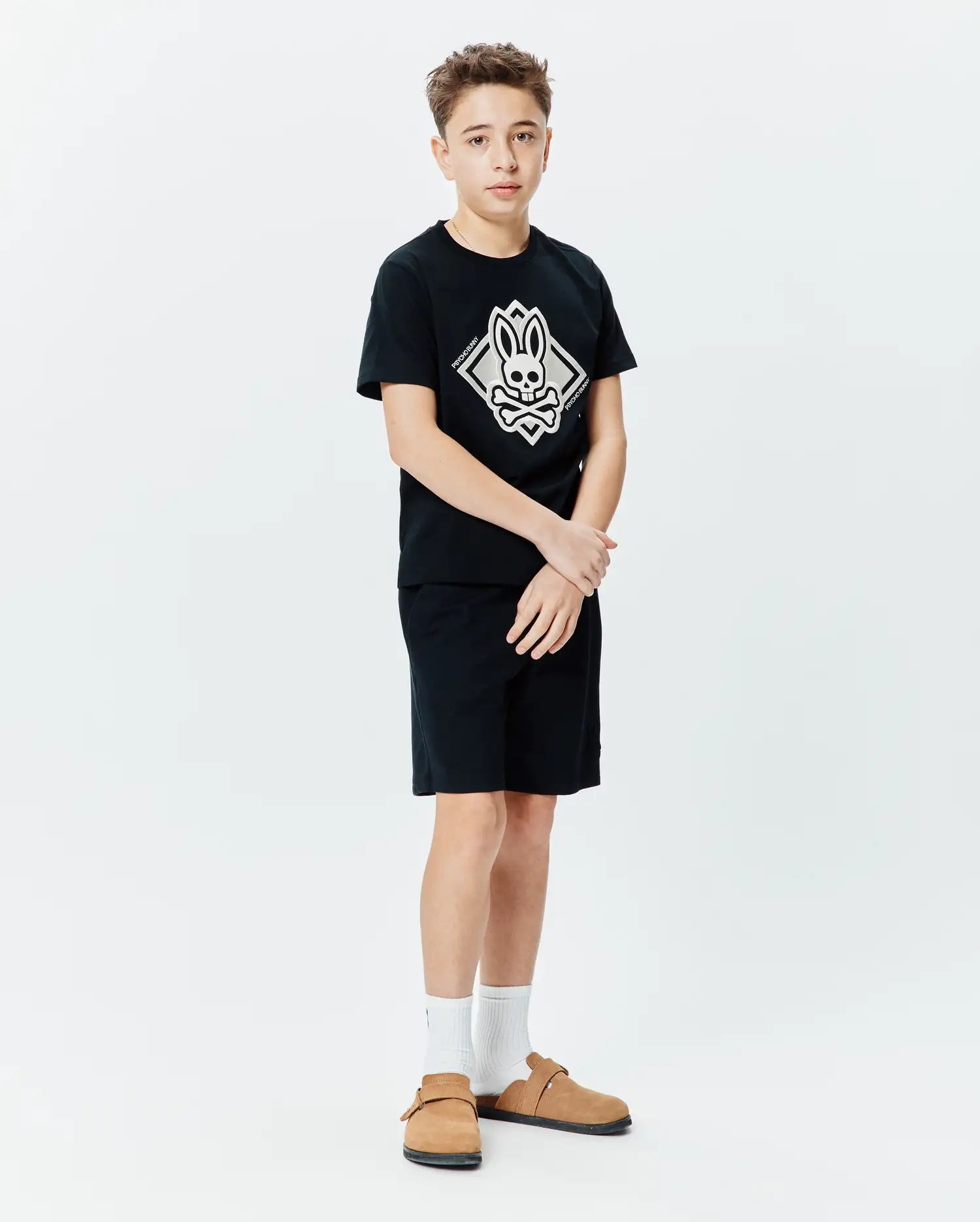Kids Tobias Graphic Tee, black jersey knit, classic fit, featuring a large central white and grey Psycho Bunny skull and crossbones diamond graphic with vertical brand name.