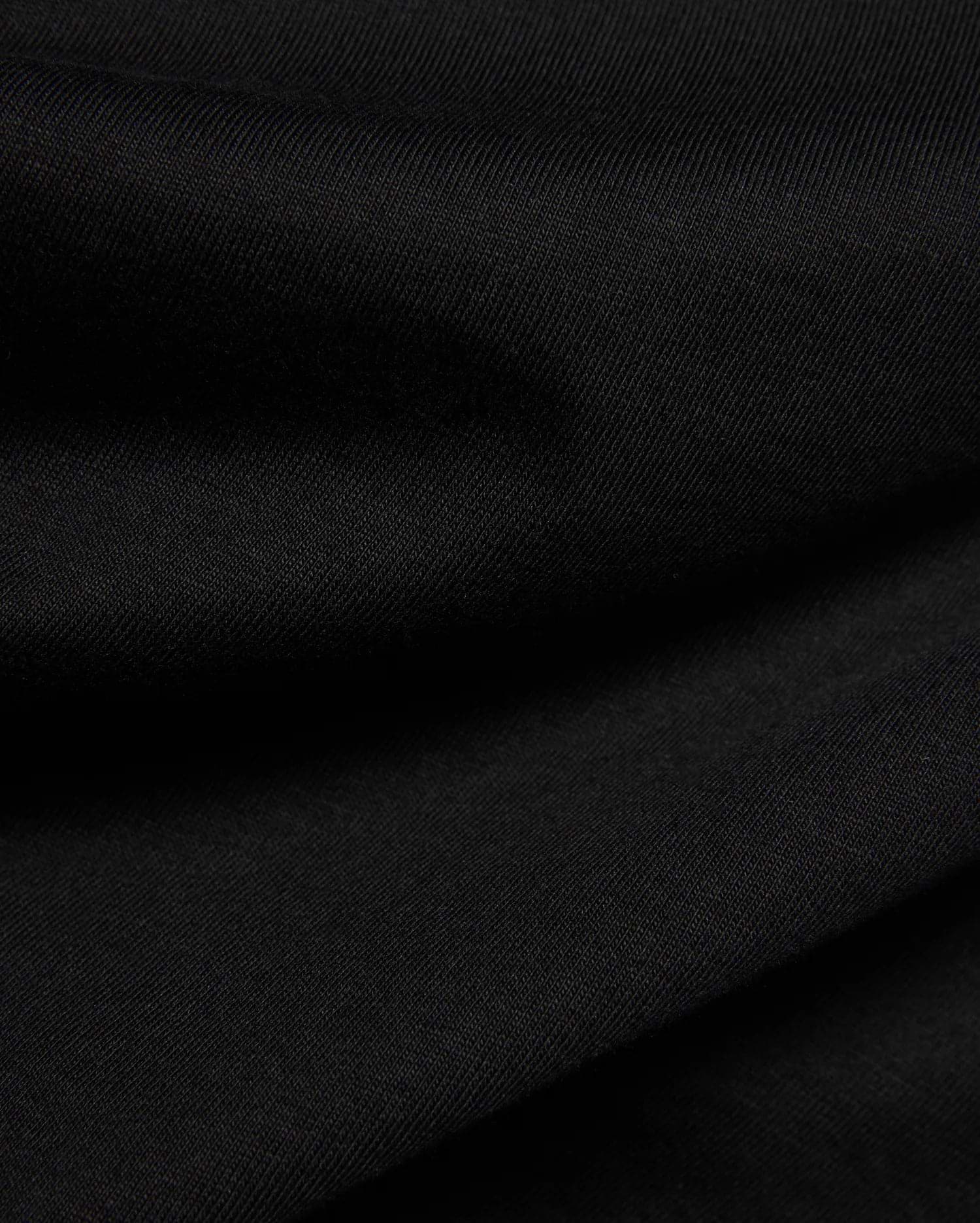 Psycho Bunny Kids Frank Back Graphic Tee in a rich black, soft jersey knit fabric with a subtle diagonal rib texture, featuring a bold back graphic.