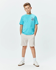 Kids Isaac Relaxed Fit Tee in bright blue jersey with a blue and white abstract bunny skull chest graphic, paired with light beige shorts featuring a small embroidered Psycho Bunny logo on the left thigh.