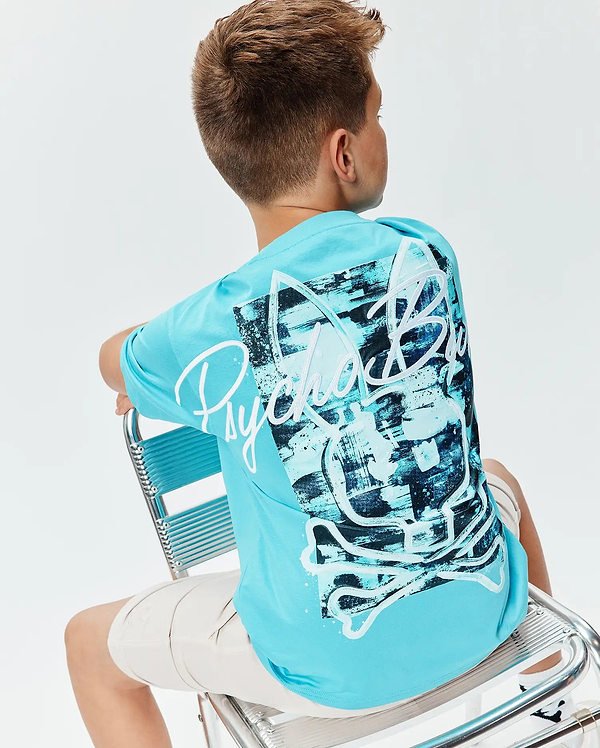 Kids Isaac Relaxed Fit Tee in aqua blue jersey, featuring a large back graphic with a white Psycho Bunny skull and script logo over an abstract black and blue brushstroke pattern.