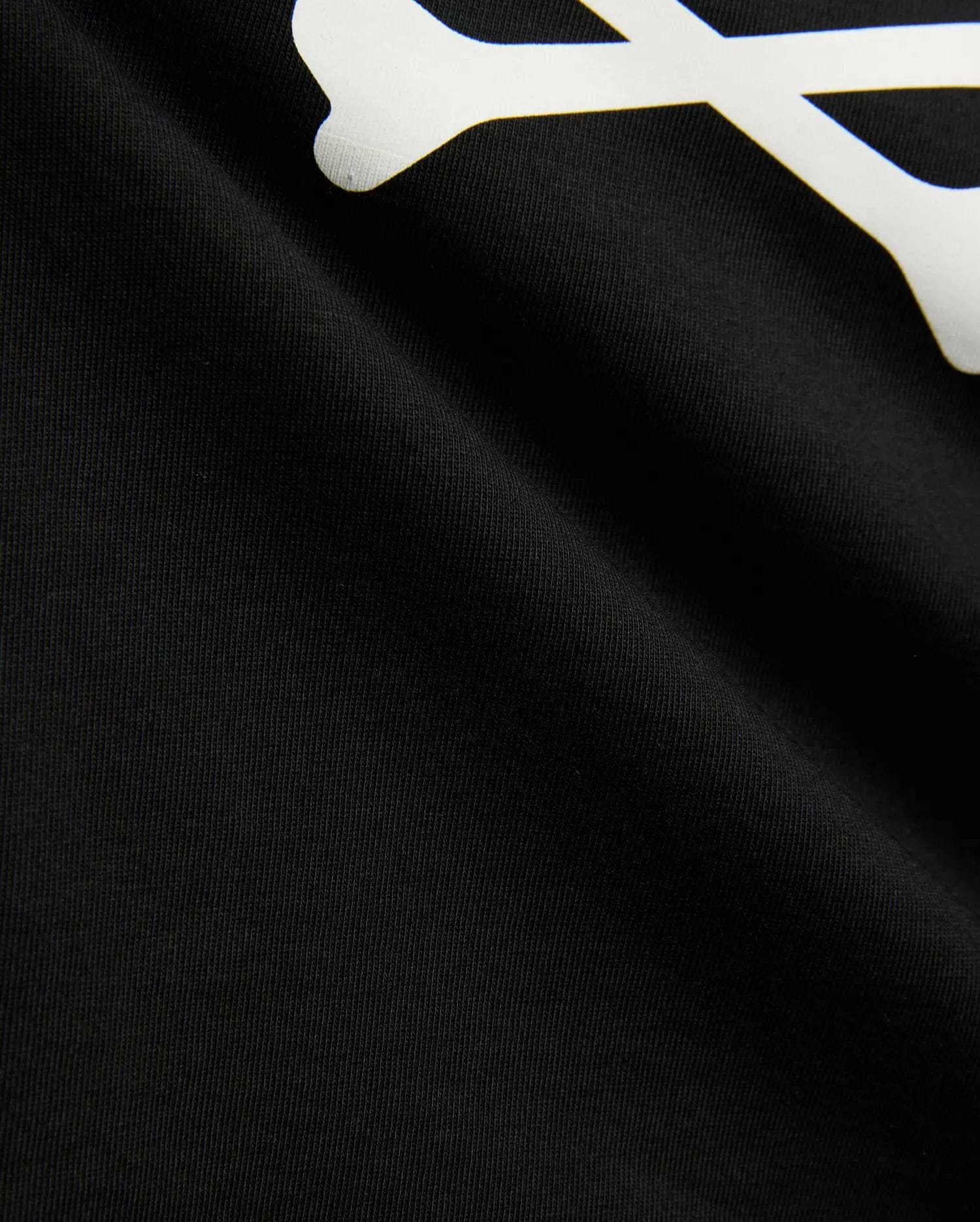 Kids Sunny Graphic Tee in black jersey knit, showcasing a large white graphic print of a bone, a key element of the iconic Psycho Bunny skull and crossbones logo.