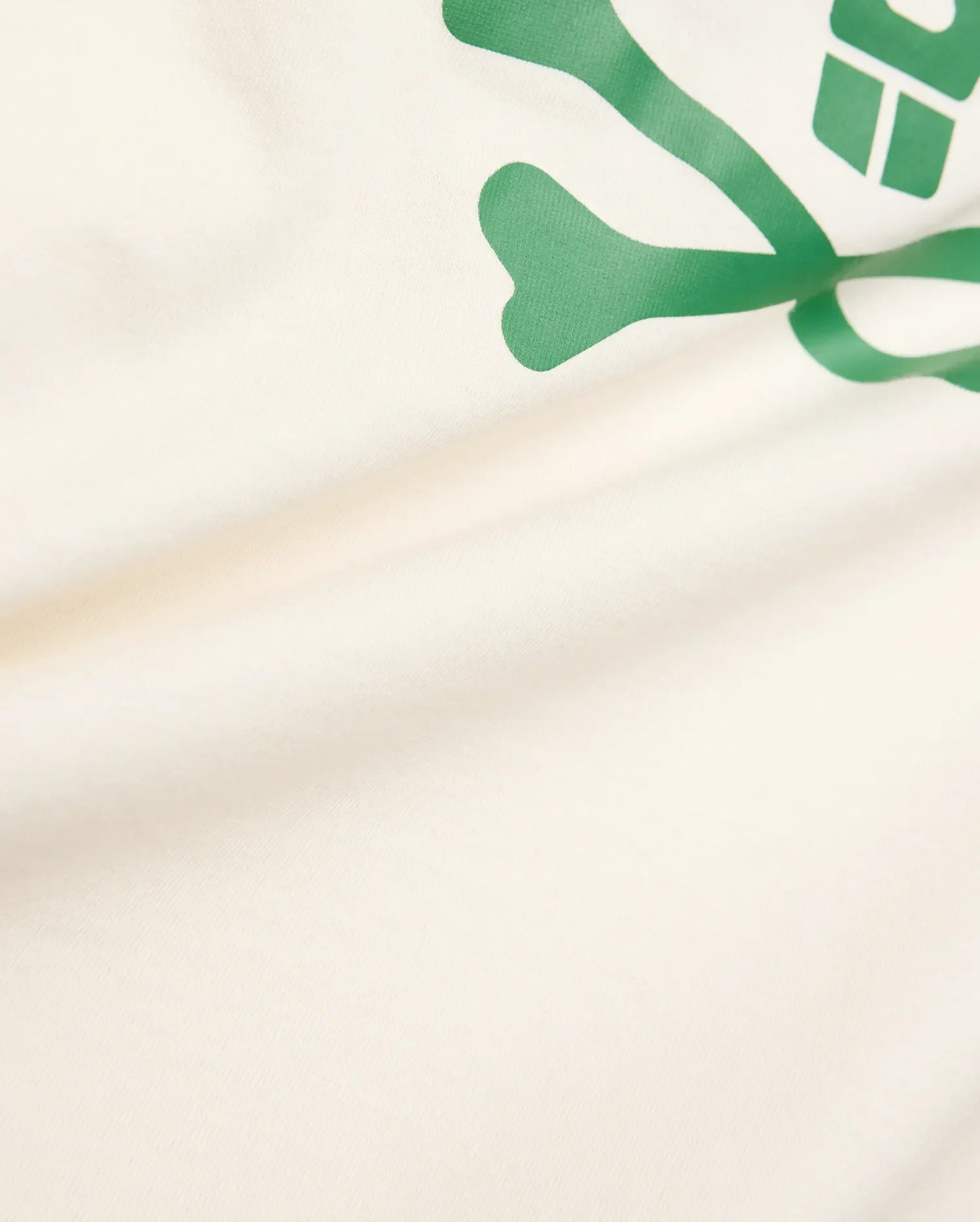 Kids Sunny Graphic Tee crafted from soft cream jersey knit, showcasing a prominent, vibrant green Psycho Bunny skull and crossbones graphic print for a comfortable classic fit.