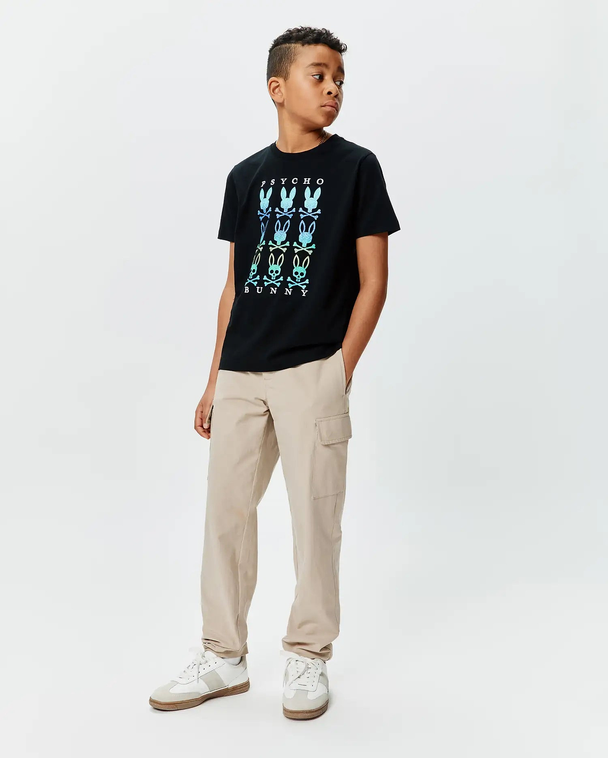Kids Colt Graphic Tee, a black classic fit jersey t-shirt featuring a large center chest gradient graphic of PSYCHO BUNNY text and multiple bunny skull logos in blue, green, and yellow.