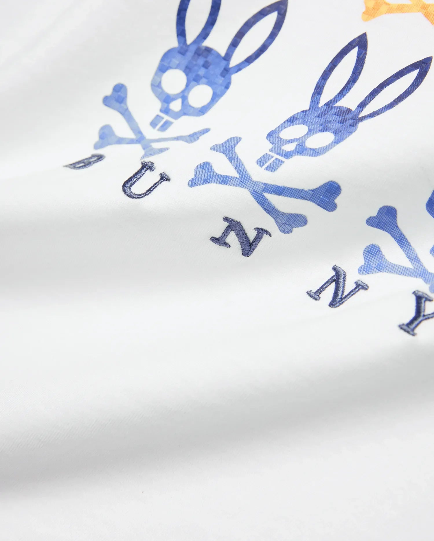 Kids Colt Graphic Tee in white jersey, featuring a large blue and orange gradient Psycho Bunny skull and crossbones graphic with embroidered dark blue BUNNY letters.