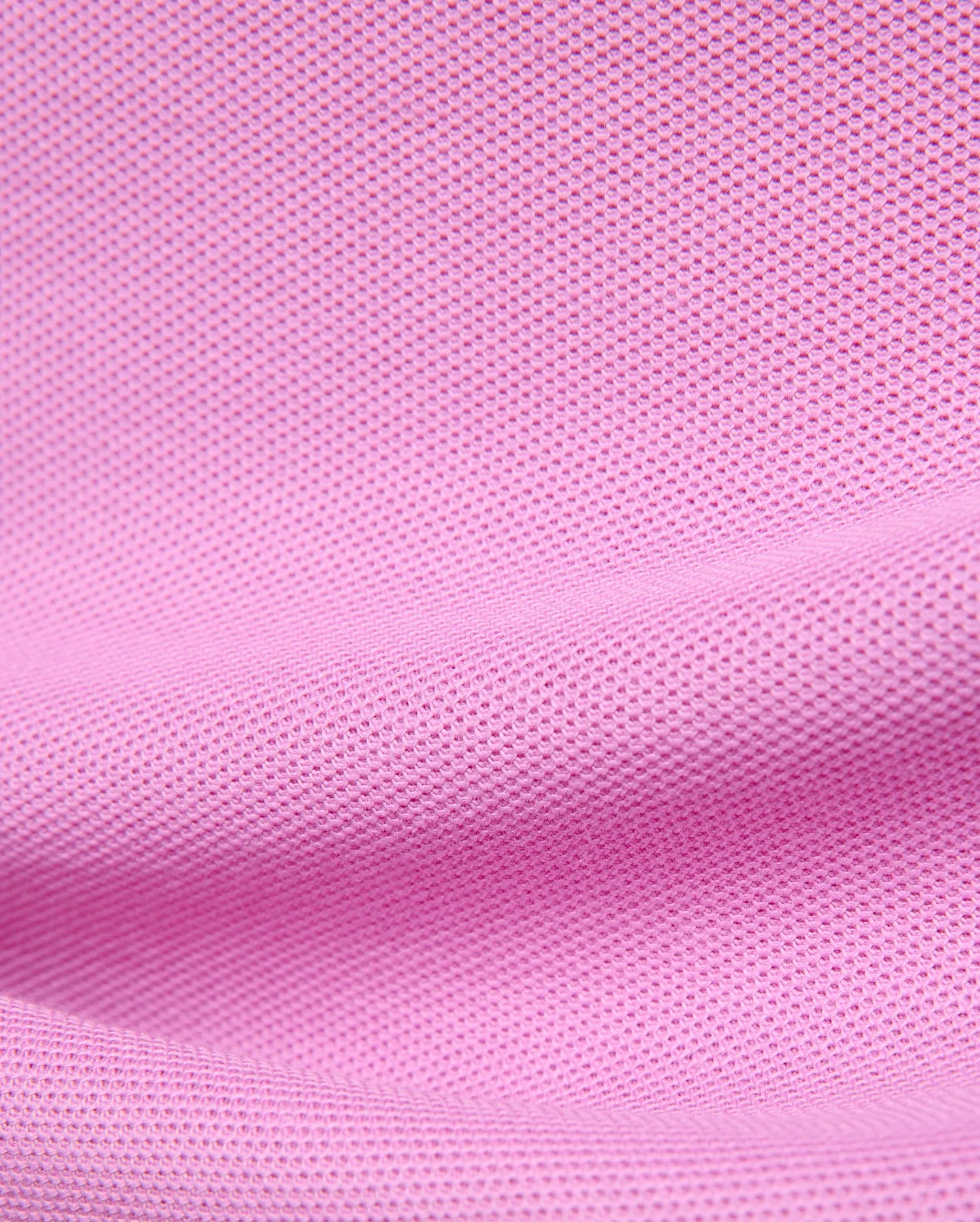 Premium Kids Taylor Pique Tee in vibrant pink, showcasing the refined textured pique knit fabric, a classic fit, and the iconic embroidered Psycho Bunny skull logo on the chest.
