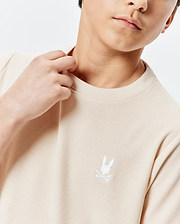 Kids Taylor Pique Tee in a light beige, classic fit, with a visible pique texture. Features a small, crisp white embroidered Psycho Bunny skull logo on the left chest.