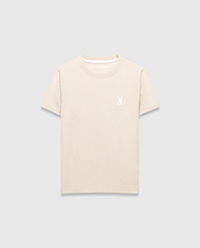 Kids Taylor Pique Tee in light beige, featuring a classic fit and pique fabric texture. It has a small, embroidered white Psycho Bunny skull logo on the left chest and a white accent trim on the collar.
