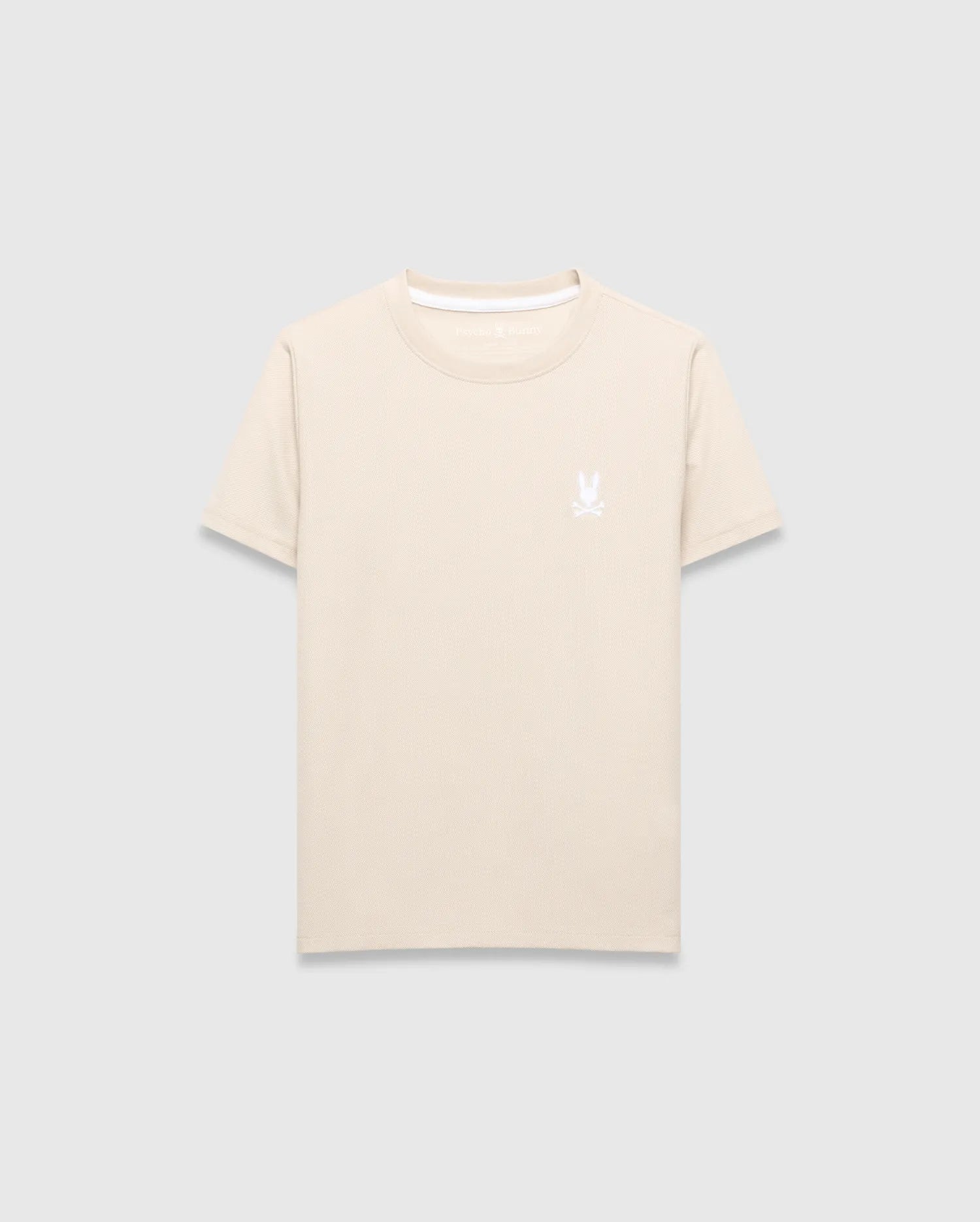 Kids Taylor Pique Tee in light beige, featuring a classic fit and pique fabric texture. It has a small, embroidered white Psycho Bunny skull logo on the left chest and a white accent trim on the collar.