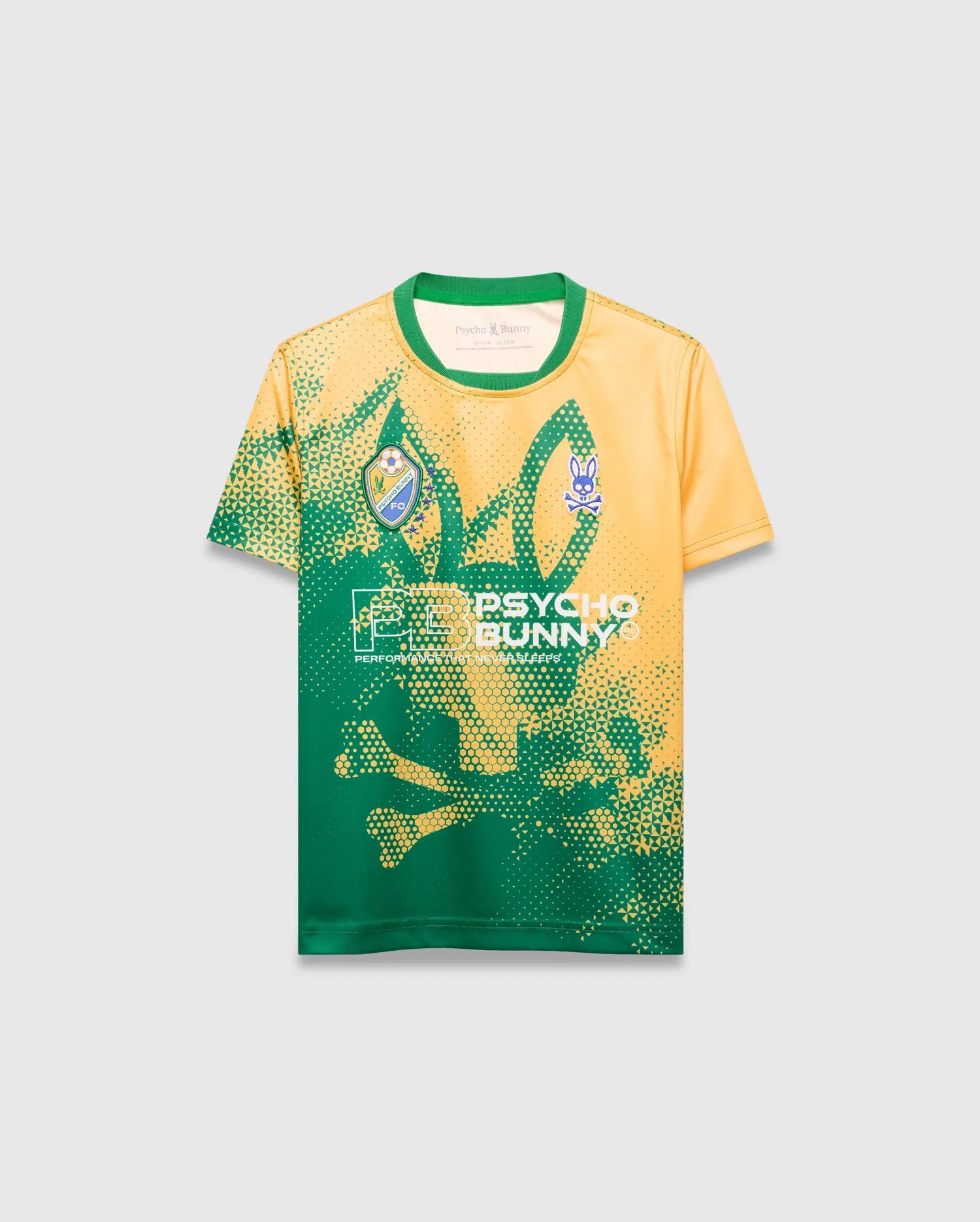 Kids Joshua Soccer Tee in yellow and green performance jersey, featuring a dynamic pixelated gradient, large central Psycho Bunny skull graphic, left chest FC crest, right chest small bunny logo, and Psycho Bunny text.