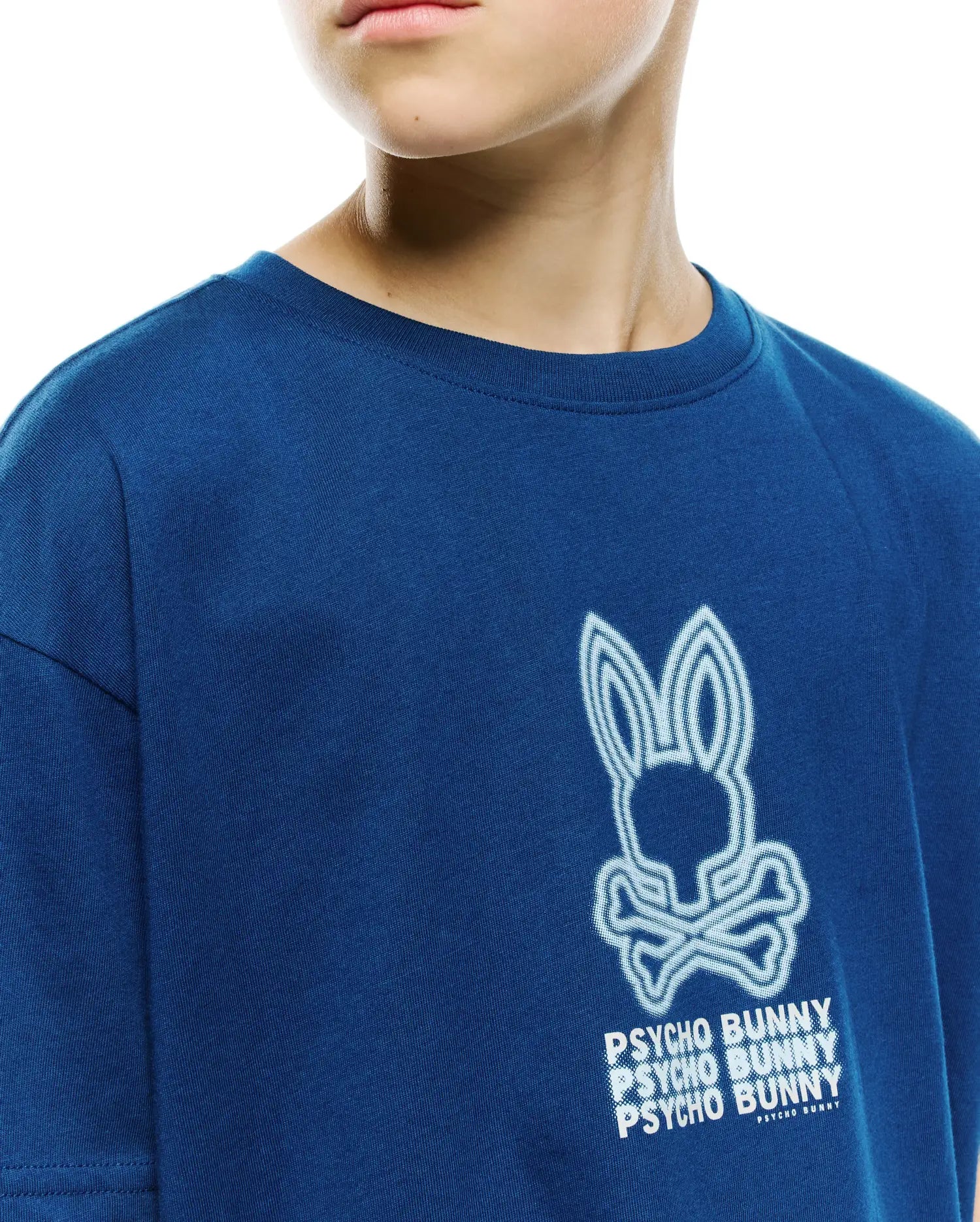 Kids Alex Relaxed Back Graphic Tee, a deep royal blue jersey shirt with a large, textured white and light blue outlined Psycho Bunny skull and stacked text graphic.