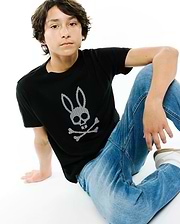 Black premium jersey Kids Stan Graphic Tee with a classic fit, showcasing a large central Psycho Bunny skull logo graphic featuring a distinctive white and black checkered pattern.
