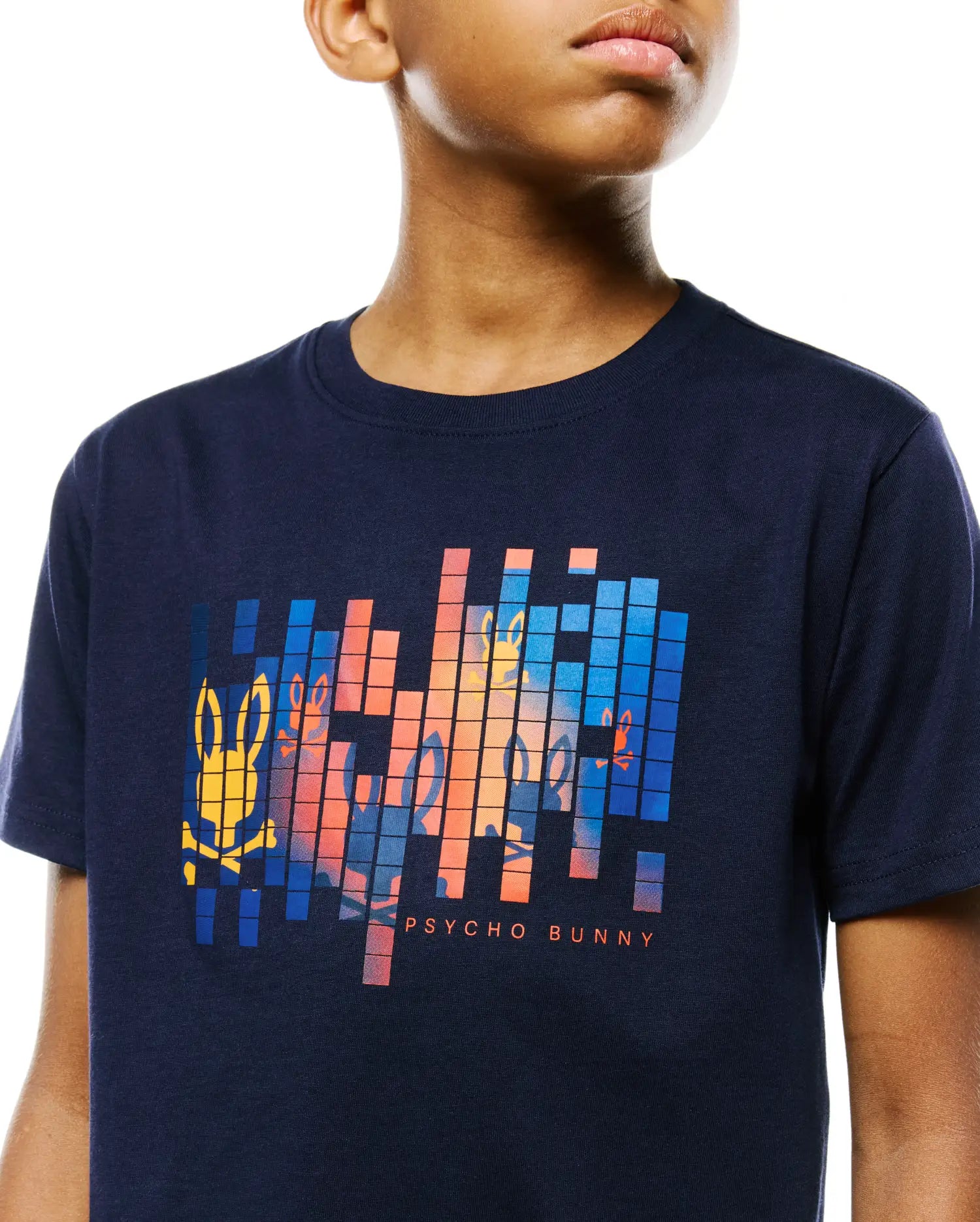 Kids Zander Graphic Tee in navy jersey, featuring a large pixelated chest graphic with orange, blue, and yellow Psycho Bunny skull logos and text, in a classic fit.