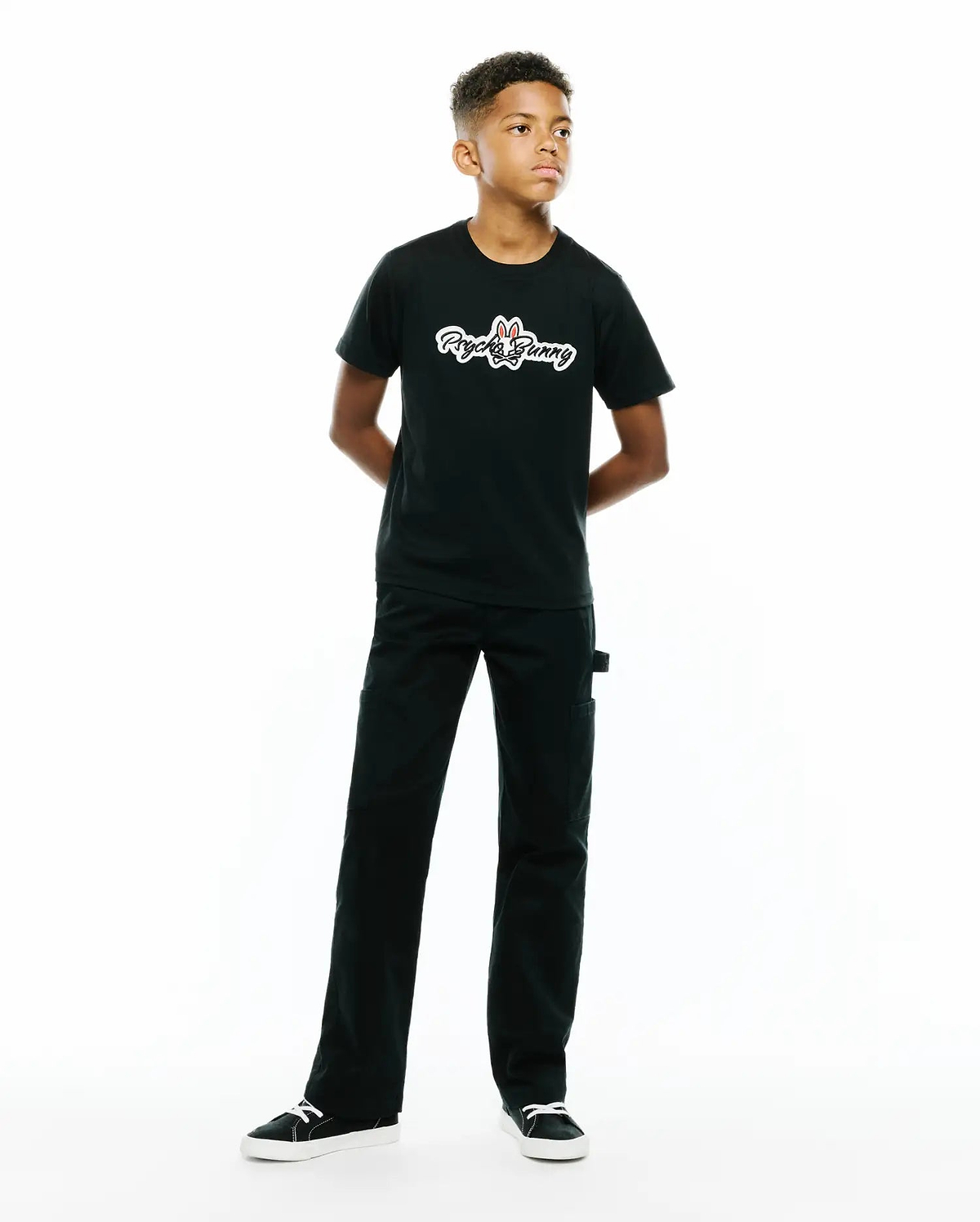 Kids Jaydon Wordmark Graphic Tee, a black classic fit soft jersey t-shirt featuring a prominent white Psycho Bunny wordmark graphic with a red-eared bunny skull logo on the center chest.