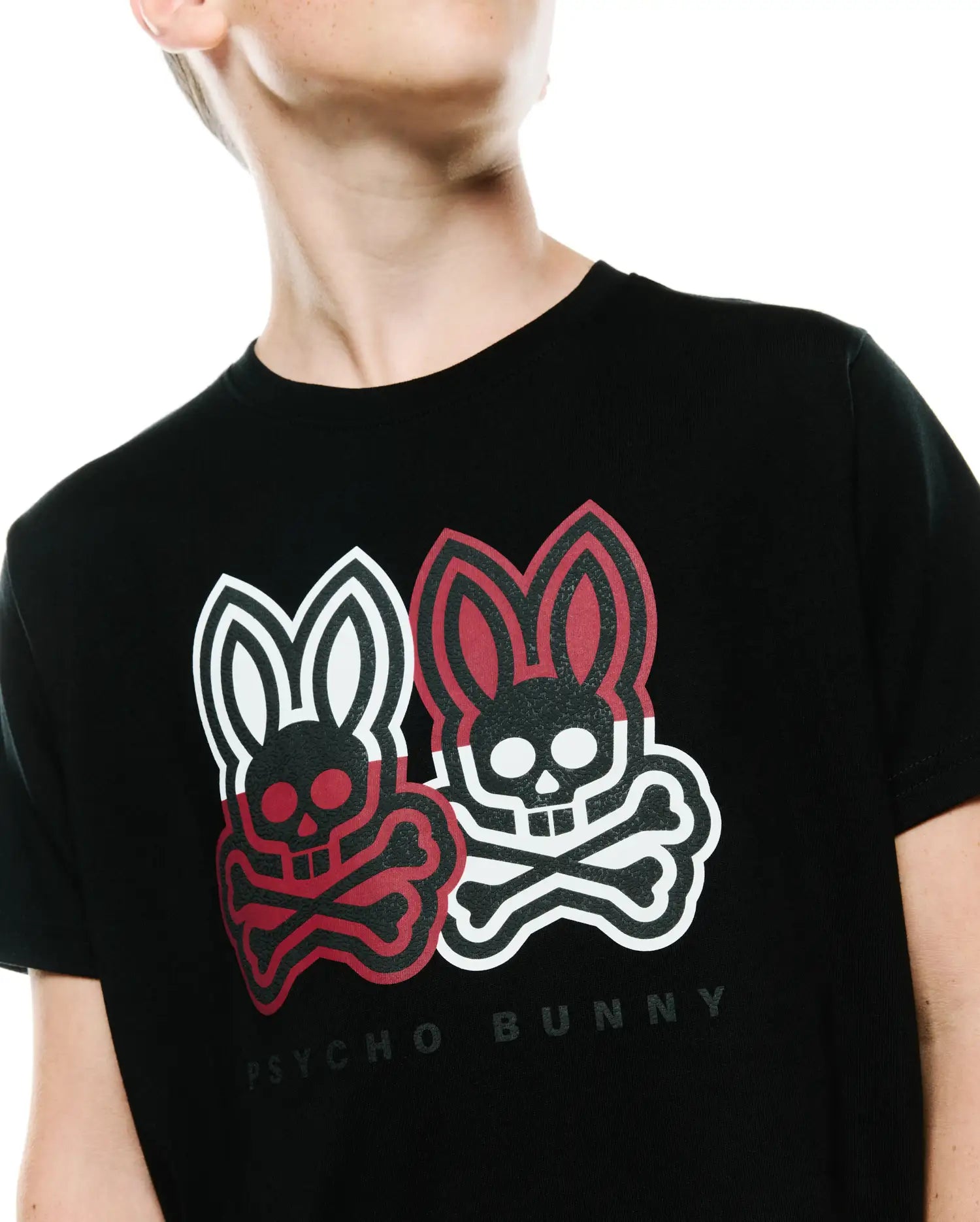 Kids Ledger Graphic Tee, a black classic fit jersey t-shirt featuring a large chest graphic of two Psycho Bunny skull logos, one red and one white, with crossbones and Psycho Bunny text.