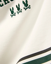 Kids Mike Graphic Jersey Tee in white jersey knit, featuring multiple small embroidered dark green Psycho Bunny skull logos and a bottom stripe design with dark green and black accents.