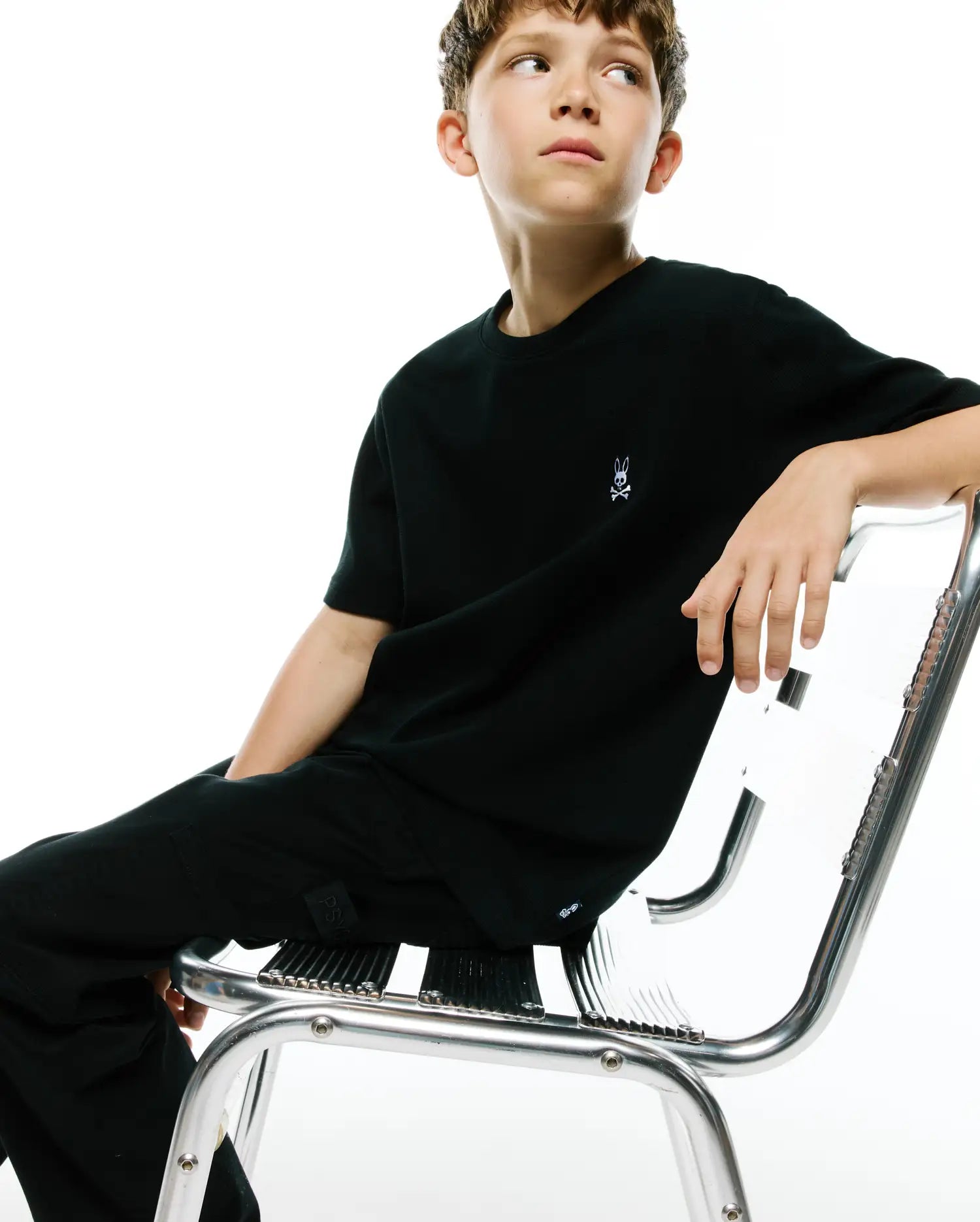 Black Kids Maxton Waffle Tee with a classic fit, featuring a subtle waffle knit texture and a small embroidered white Psycho Bunny skull logo on the left chest. (1)