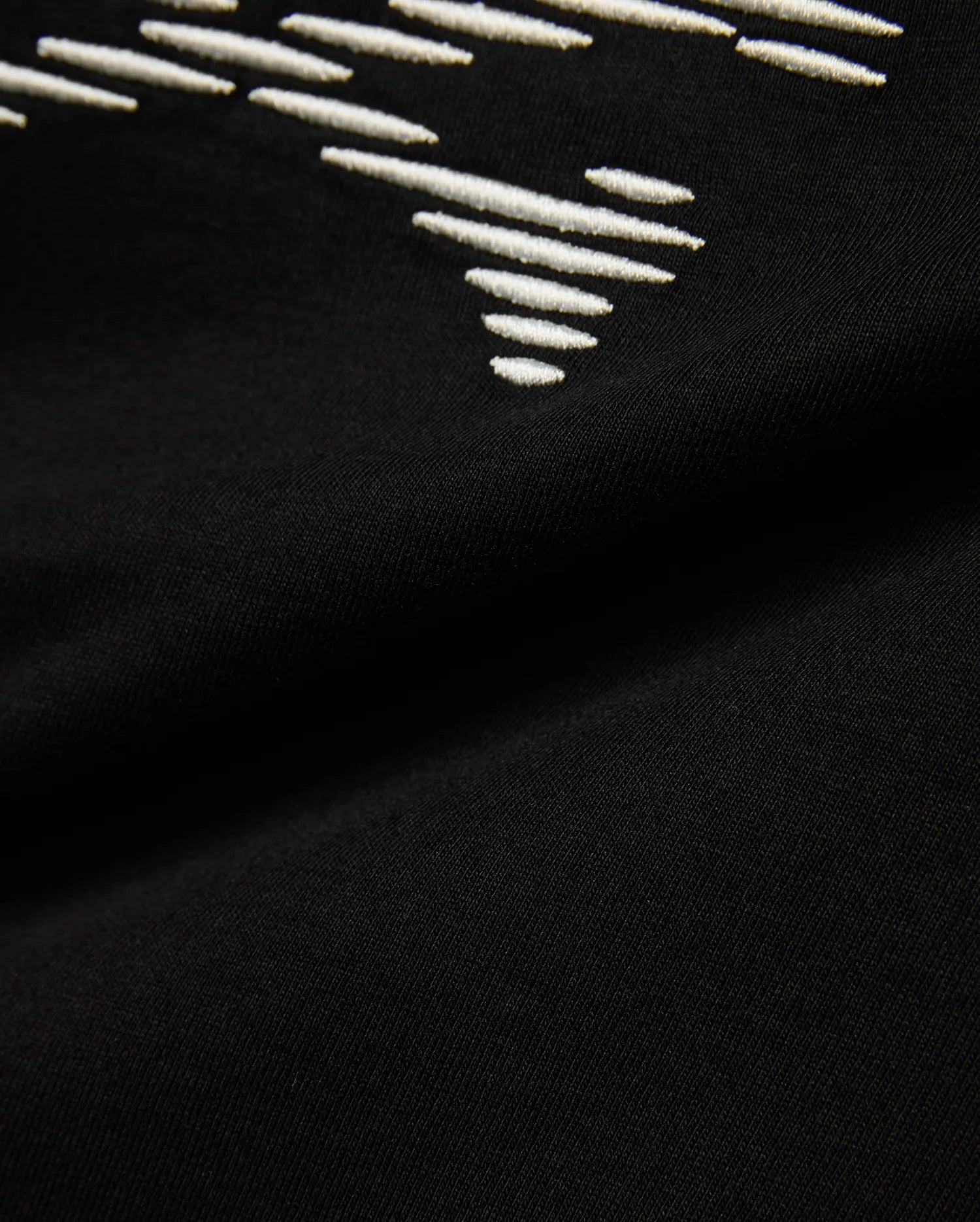 Kids' Slade Pima Graphic Tee, a black Pima cotton jersey t-shirt with a refined streetwear feel, featuring a prominent white embroidered stylized graphic design. (6)