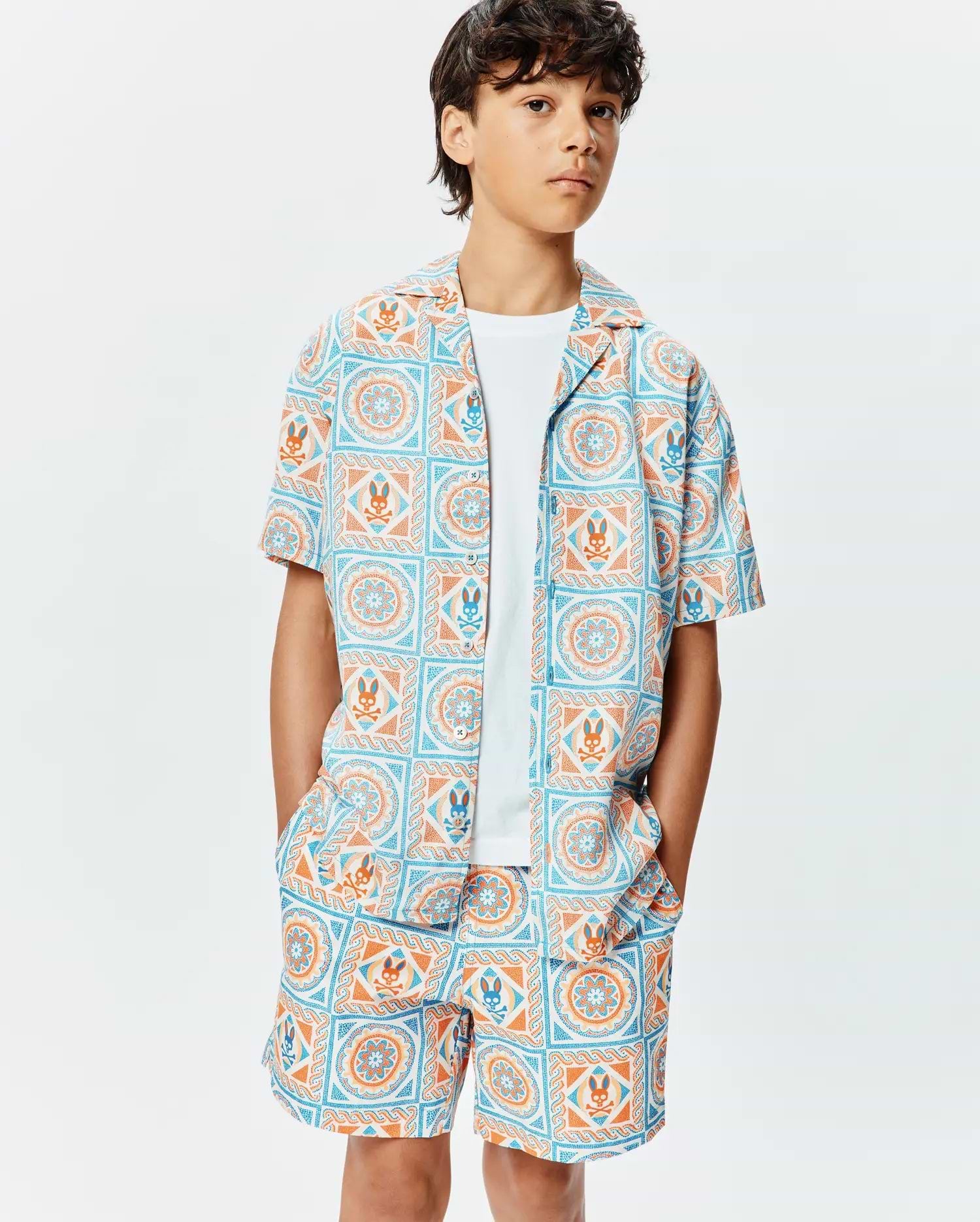 Kids Frank Tencel Shirt and matching shorts, featuring a relaxed fit and an all-over light blue and orange geometric tile print with integrated Psycho Bunny skull logos.