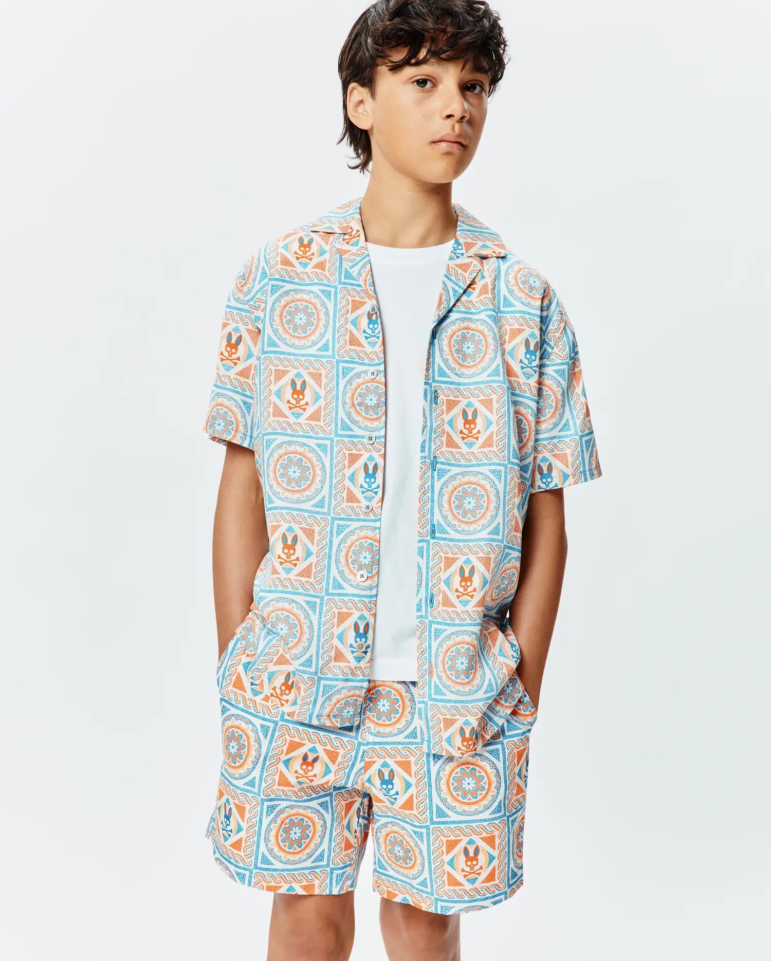 Kids Frank Tencel Shirt and matching shorts, featuring a relaxed fit and an all-over light blue and orange geometric tile print with integrated Psycho Bunny skull logos.