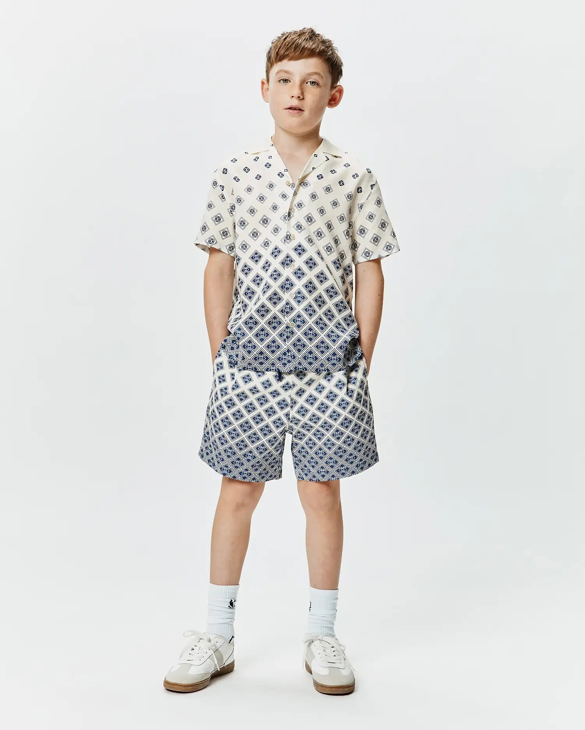 Psycho Bunny Kids Tobias Tencel Shirt and matching shorts, cream with a blue geometric diamond pattern, relaxed fit, featuring a gradient effect on the shirt.