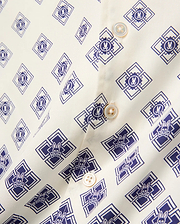 Kids Tobias Tencel Shirt in off-white with an all-over navy blue geometric pattern featuring the iconic Psycho Bunny skull logo, detailed with light brown buttons.