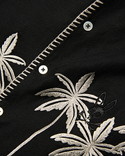 Kids Brad Linen Shirt, black with intricate off-white embroidered palm trees, a small black Psycho Bunny skull logo, and decorative zigzag placket stitching.