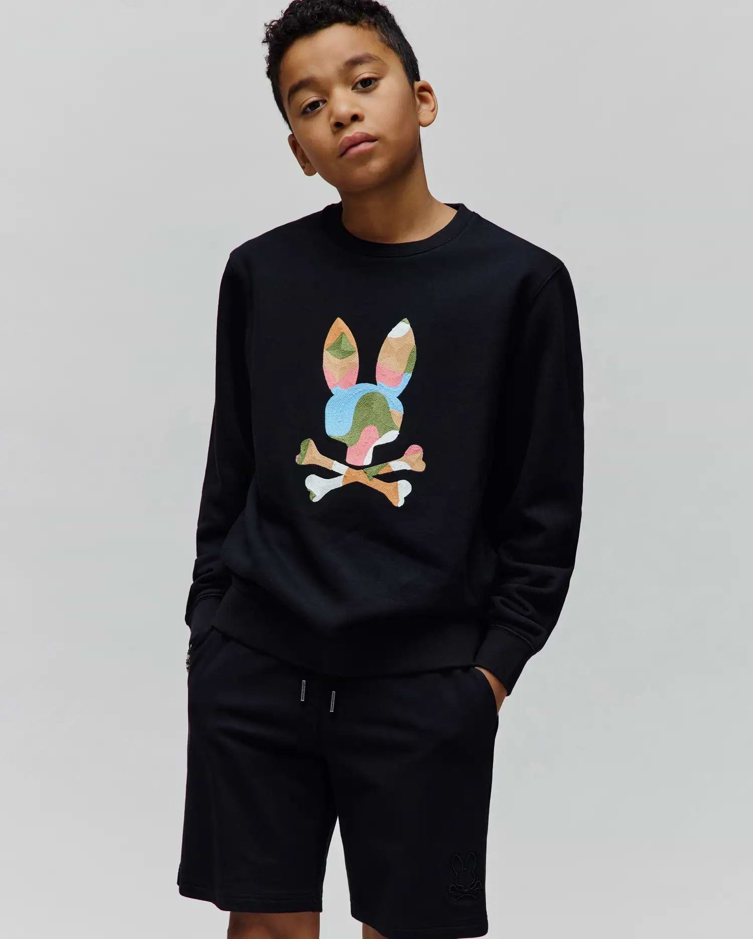 Black Kids Ara Crew sweatshirt, relaxed fit, featuring a large, vibrant multi-color camouflage Psycho Bunny skull logo on the chest, paired with black jersey shorts with a small tonal embroidered bunny skull logo.