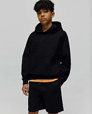 Kids Dustin Hoodie, a black relaxed fit hoodie featuring an all-over embossed Psycho Bunny skull pattern on textured knit fabric, with a subtle orange accent. (4)