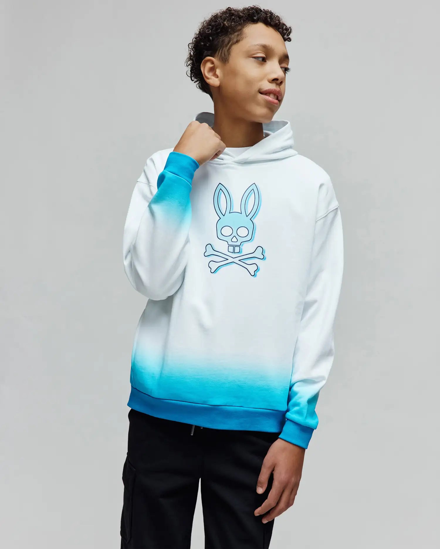 Kids Dax Oversized Hoodie in white to blue ombre, featuring a large central outlined Psycho Bunny skull logo, crafted from smooth jersey fabric for a relaxed fit.