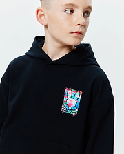 Kids Isaac Print Hoodie, black relaxed fit jersey hoodie with a small, vibrant multi-color graphic print of the Psycho Bunny skull logo on the chest, featuring pink, blue, and green splashes.