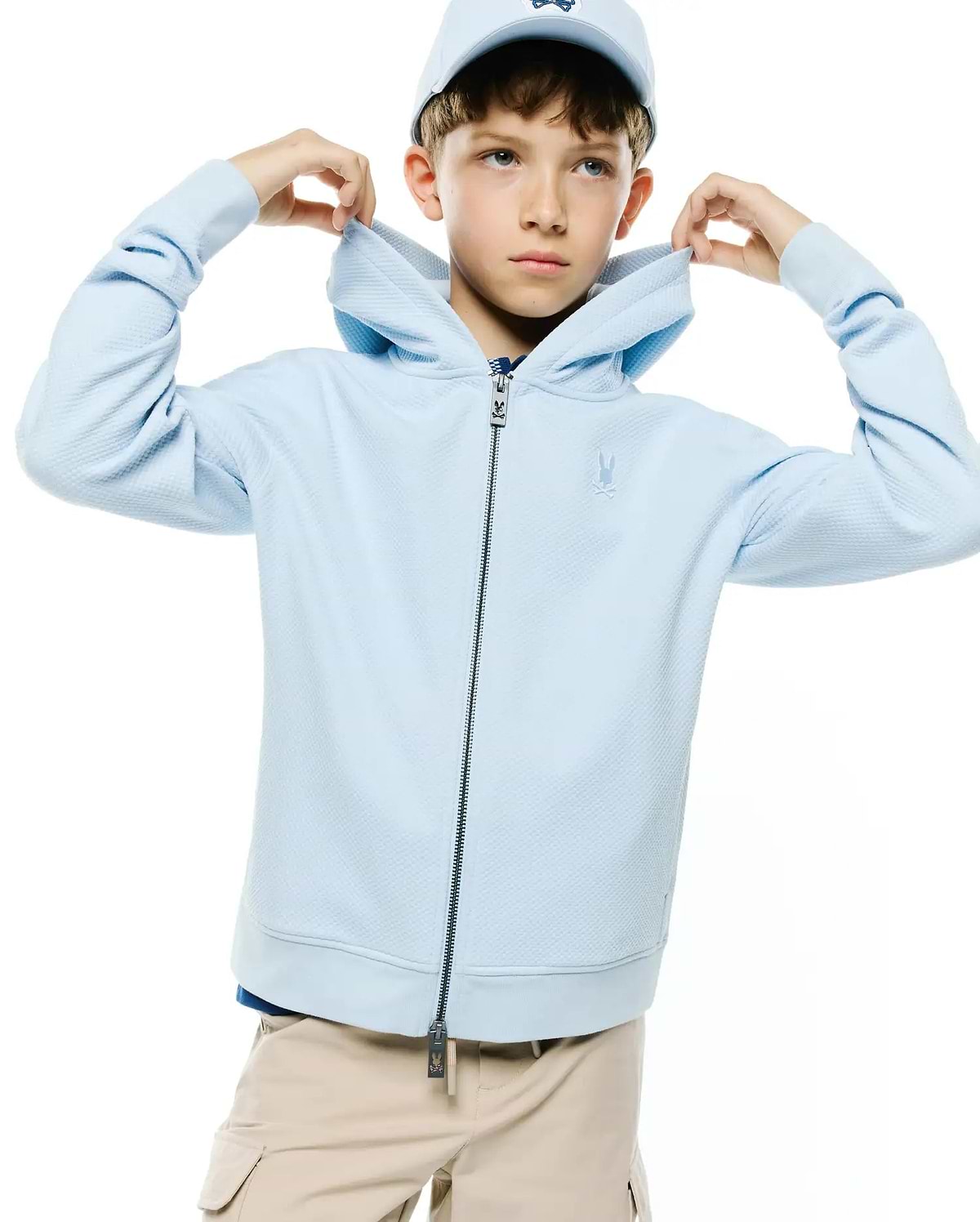 Kids Marc Textured Full Zip Hoodie in light blue, featuring a subtle textured knit, full dark zipper with Psycho Bunny logo pull, and a small embroidered tonal bunny skull on the left chest.