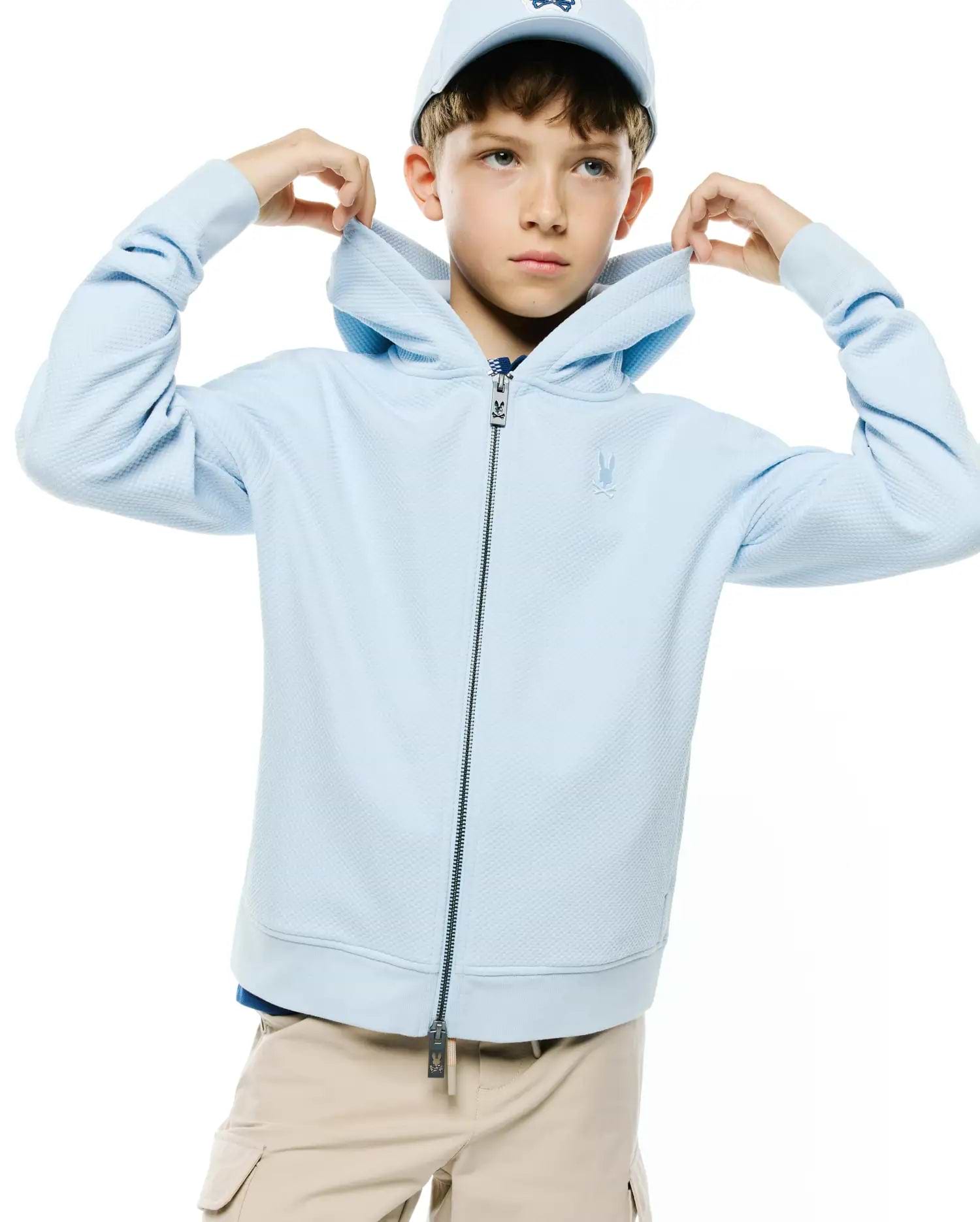Kids Marc Textured Full Zip Hoodie in light blue, featuring a subtle textured knit, full dark zipper with Psycho Bunny logo pull, and a small embroidered tonal bunny skull on the left chest.