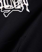 Kids Nathaniel Relaxed Hoodie in black, crafted from soft French terry, showcasing a prominent white embroidered Psycho Bunny skull and crossbones logo for a relaxed fit.