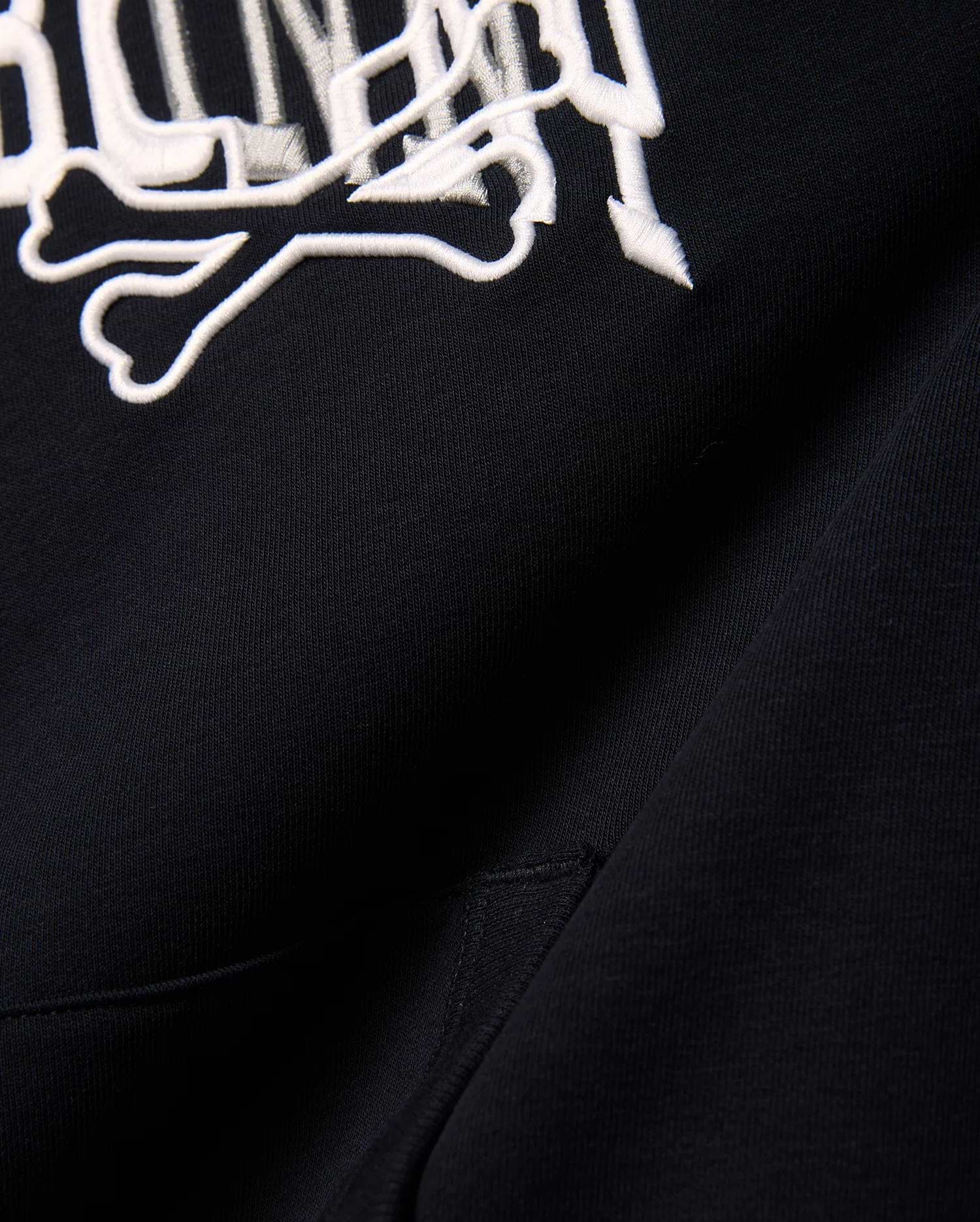 Kids Nathaniel Relaxed Hoodie in black, crafted from soft French terry, showcasing a prominent white embroidered Psycho Bunny skull and crossbones logo for a relaxed fit.
