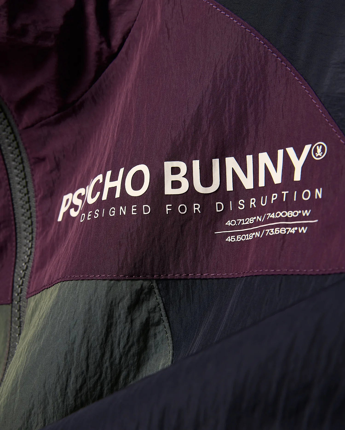 Kids Alder Nylon Colorblock Jacket in plum, olive, and navy, featuring a large white Psycho Bunny logo, Designed For Disruption text, and coordinates on crinkled nylon fabric. (6)