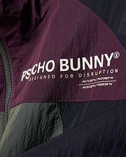 Kids Alder Nylon Colorblock Jacket in plum, olive, and navy, featuring a large white Psycho Bunny logo, Designed For Disruption text, and coordinates on crinkled nylon fabric. (6)