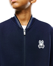 Kids Jaydon Track Jacket, navy smooth jersey, classic fit, full-zip with branded pull, ribbed collar with white and blue stripes, and an embroidered white and light blue Psycho Bunny skull logo on the left chest.