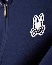 Kids Jaydon Track Jacket in navy blue, featuring a smooth knit fabric and a prominent embroidered white and light blue Psycho Bunny skull logo on the left chest, with a metallic zipper pull.