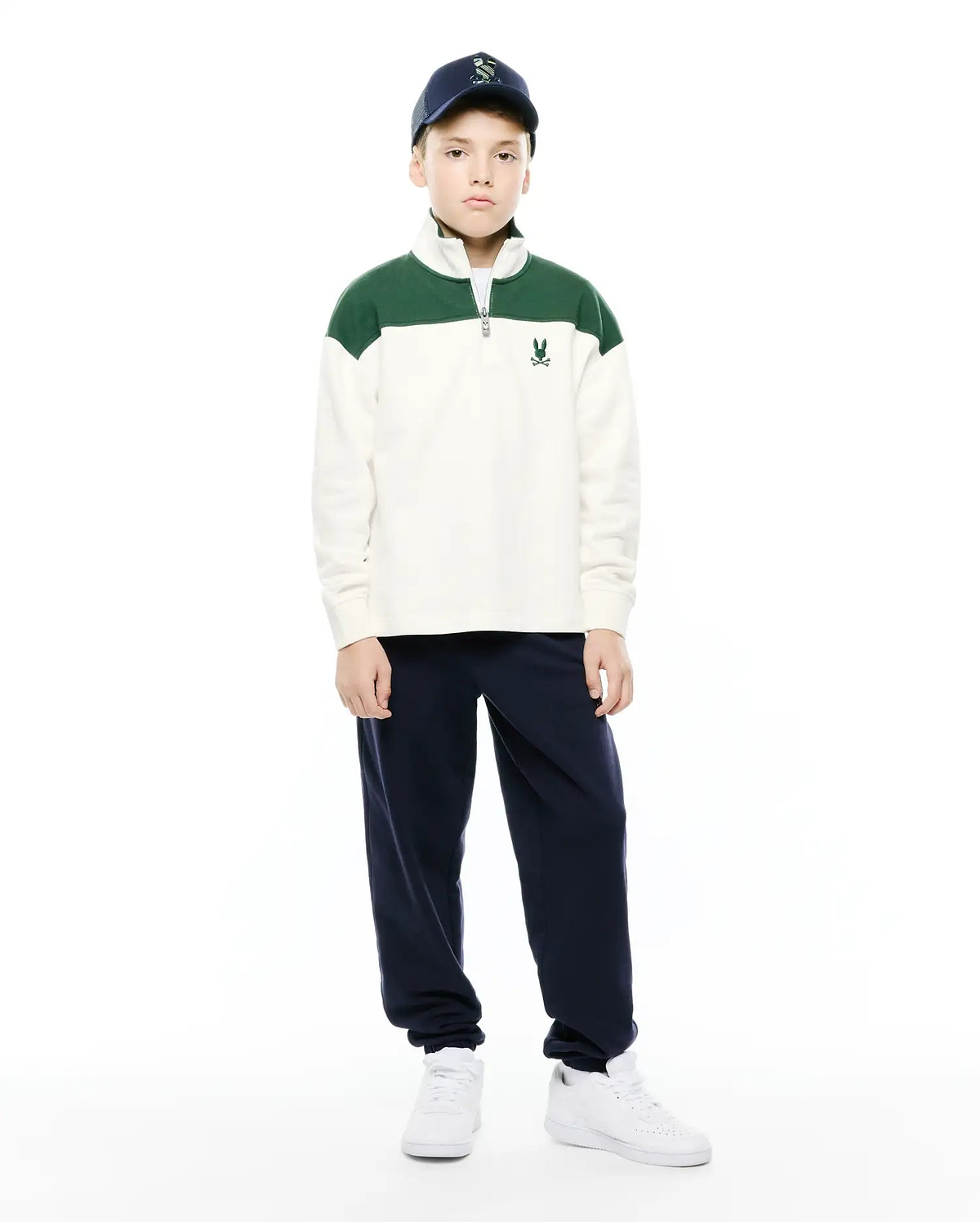 Kids Gabe French Terry 1/4 Zip, a relaxed fit cream pullover with green color-block shoulders, soft French terry fabric, a silver 1/4 zip, and a small embroidered Psycho Bunny skull logo on the left chest.