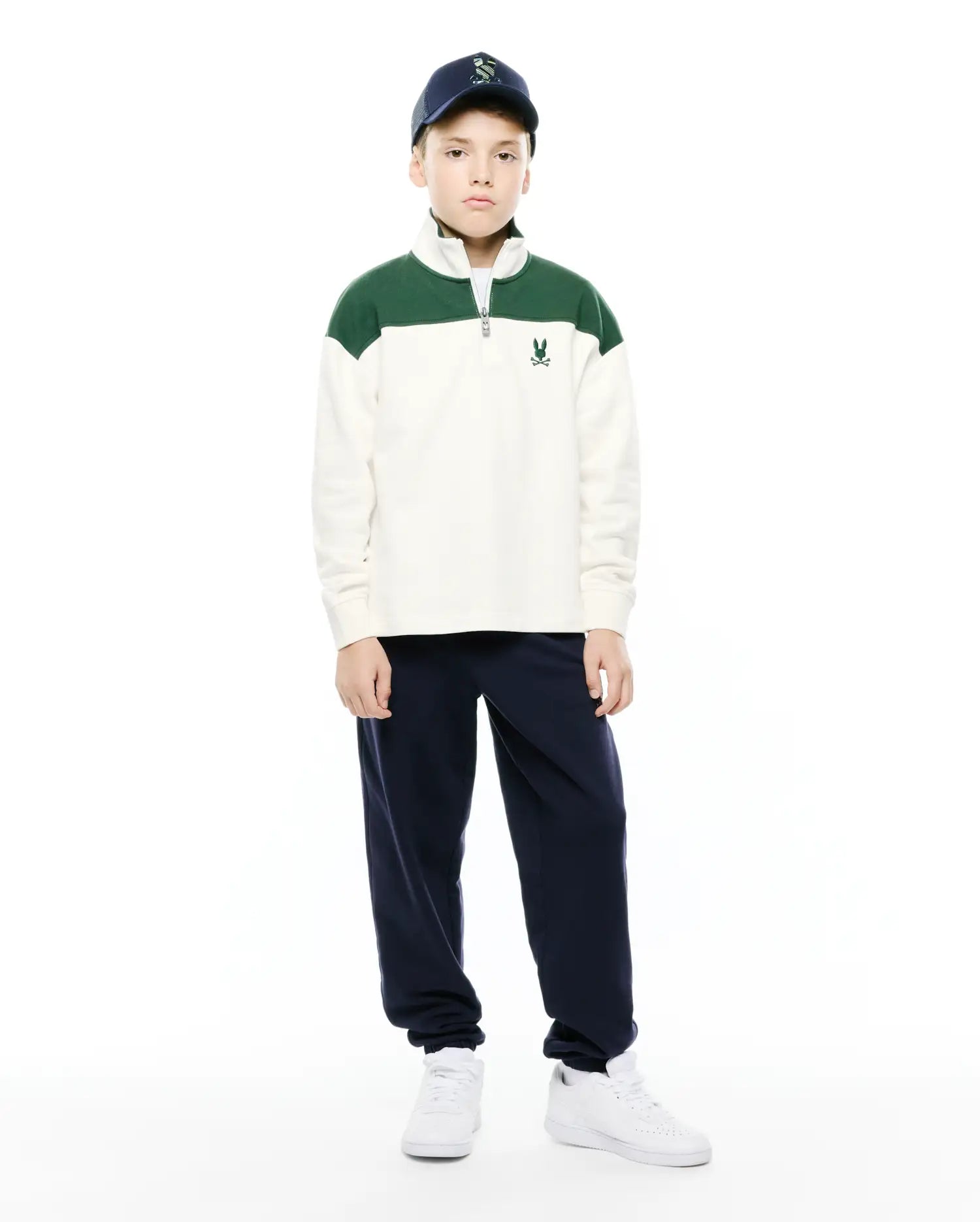 Kids Gabe French Terry 1/4 Zip, a relaxed fit cream pullover with green color-block shoulders, soft French terry fabric, a silver 1/4 zip, and a small embroidered Psycho Bunny skull logo on the left chest.