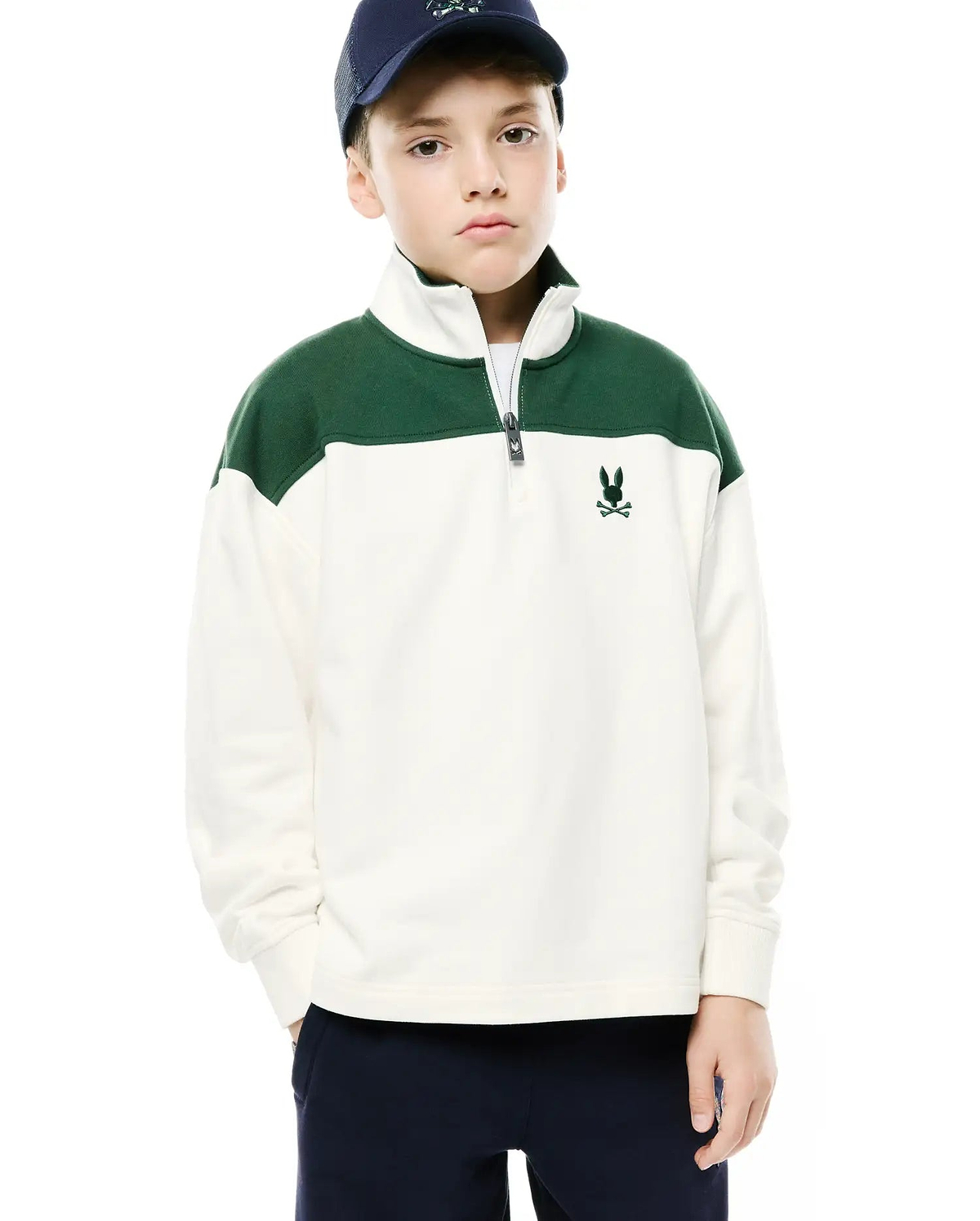 Kids Gabe French Terry 1/4 Zip in cream with dark green color block shoulders, featuring a relaxed fit, silver quarter zip, and small embroidered dark green Psycho Bunny skull logo on the left chest.