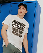 Mens Lawrence Graphic Tee, white classic fit smooth jersey knit t-shirt featuring a large, bold black blurred Psycho Bunny text graphic across the chest. (1)