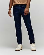 Mens Emerson Denim Pant, dark indigo slim fit denim jeans with classic five-pocket styling, subtle whiskering, and a small green Psycho Bunny logo tag on the coin pocket.