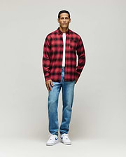 Red and black plaid flannel shirt, classic fit, featuring an all-over subtle Psycho Bunny skull pattern, layered over a white jersey t-shirt, and paired with light wash Mens Emerson Denim Pant.