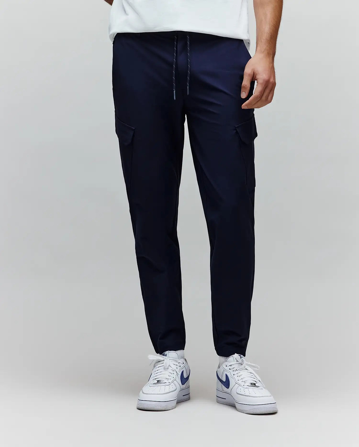 Mens Luka Cargo Pant in navy, featuring a relaxed tapered fit, smooth fabric, side cargo pockets, and a speckled drawstring waist. (1)